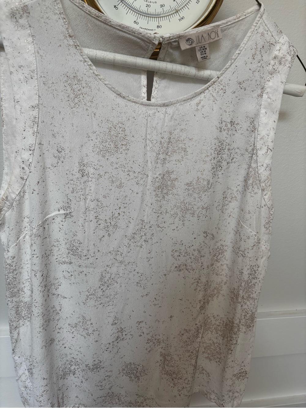 delicate beige & white speckled pattern and a small keyhole back closure.